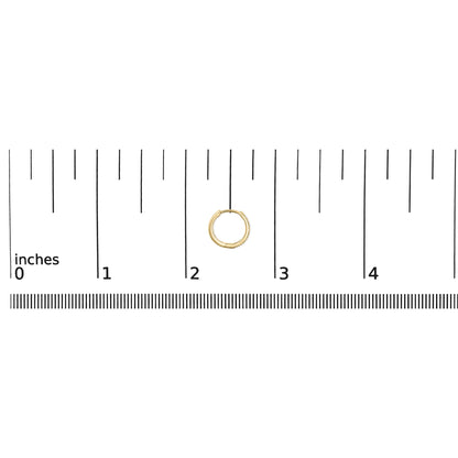 Close-up top view of a small yellow hoop earring partially adorned with round white gemstones, shown on a scale with inch measurements.
