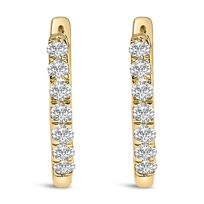 Pair of yellow metal hoop earrings with a row of round white gemstones in shared prong setting, shown from a front angle on a white background.