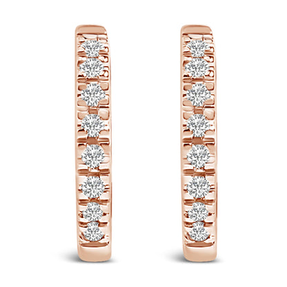 Front view of a pair of rose-colored metal hoop earrings each set with multiple round white gemstones in a 4-prong setting.