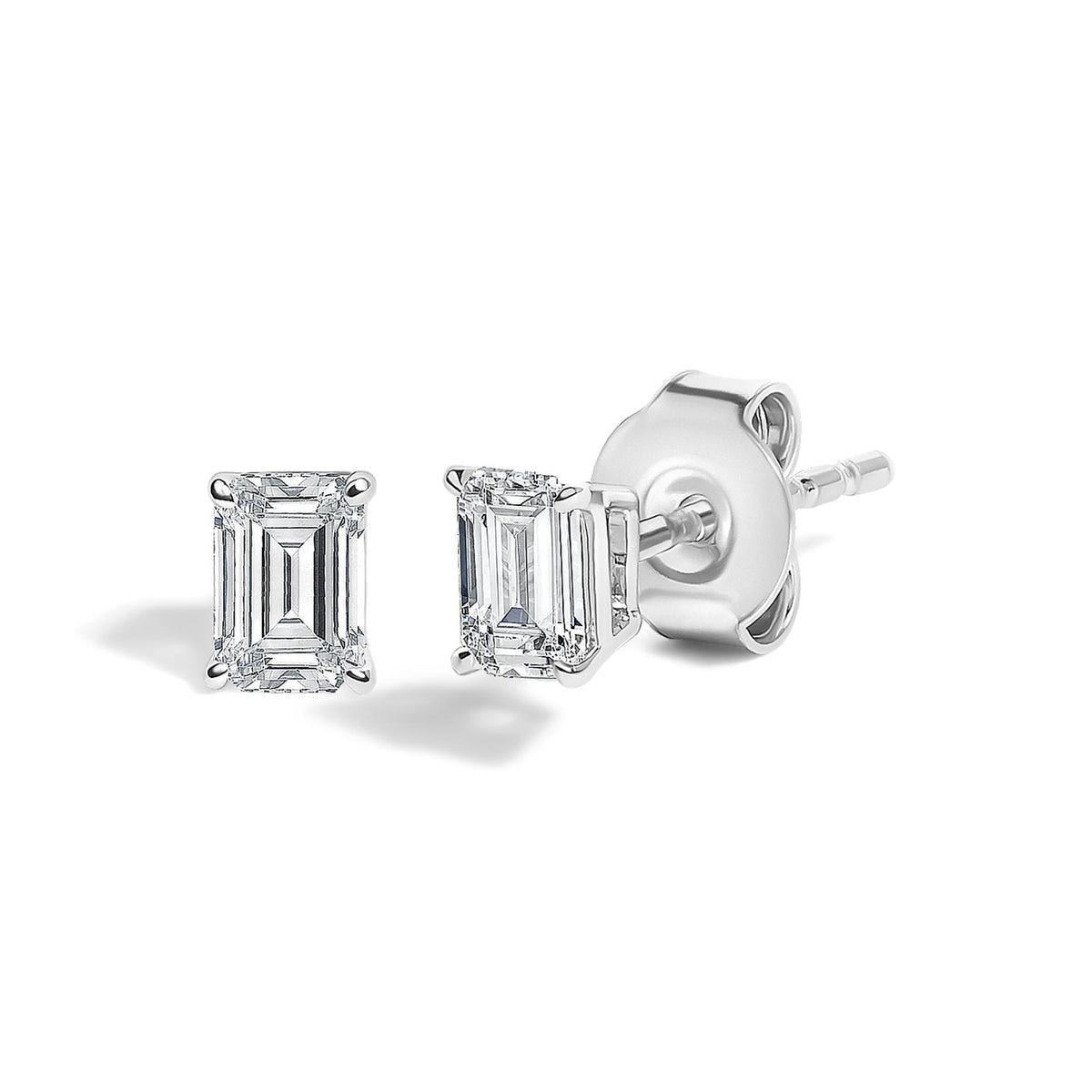 Close-up front and side view of a pair of white metal stud earrings featuring white emerald-shaped gemstones in four-prong settings.
