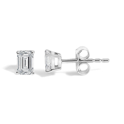 Close-up side and front view of a white metal earring with an emerald-shaped white gemstone in a four-prong setting shown on a white background.