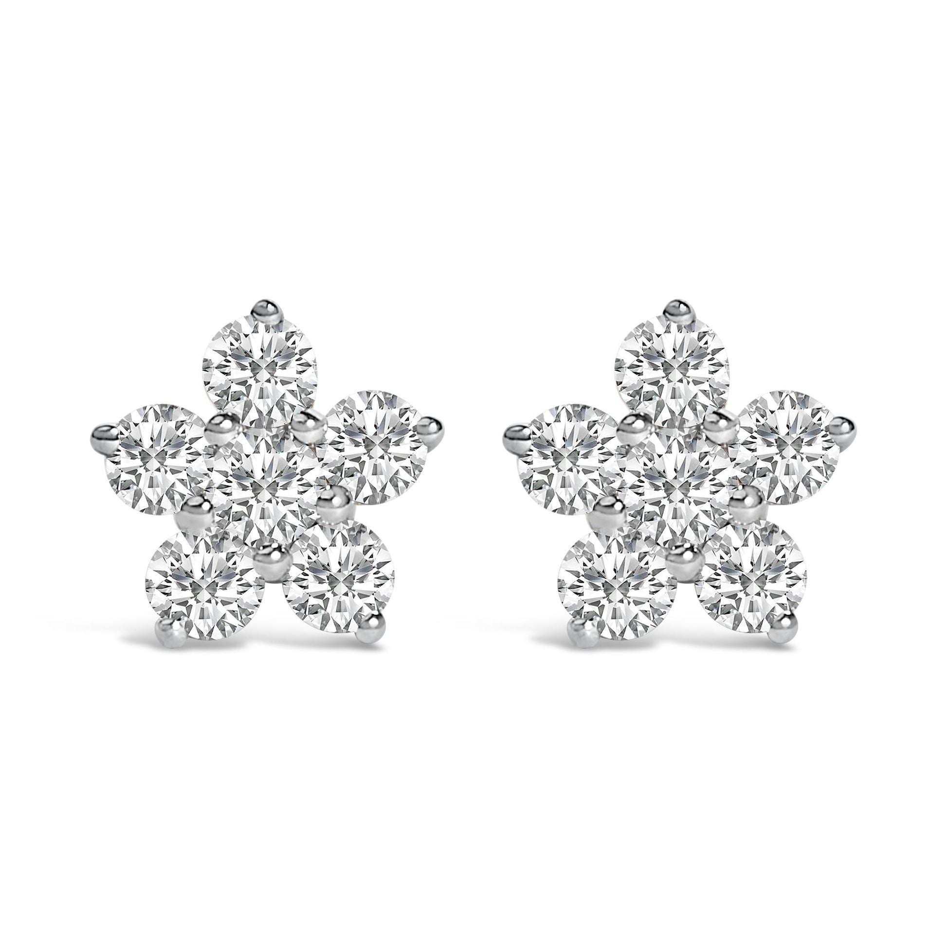 Pair of white metal flower-shaped earrings with round white gemstones in prong settings, shown from the front on a white background.
