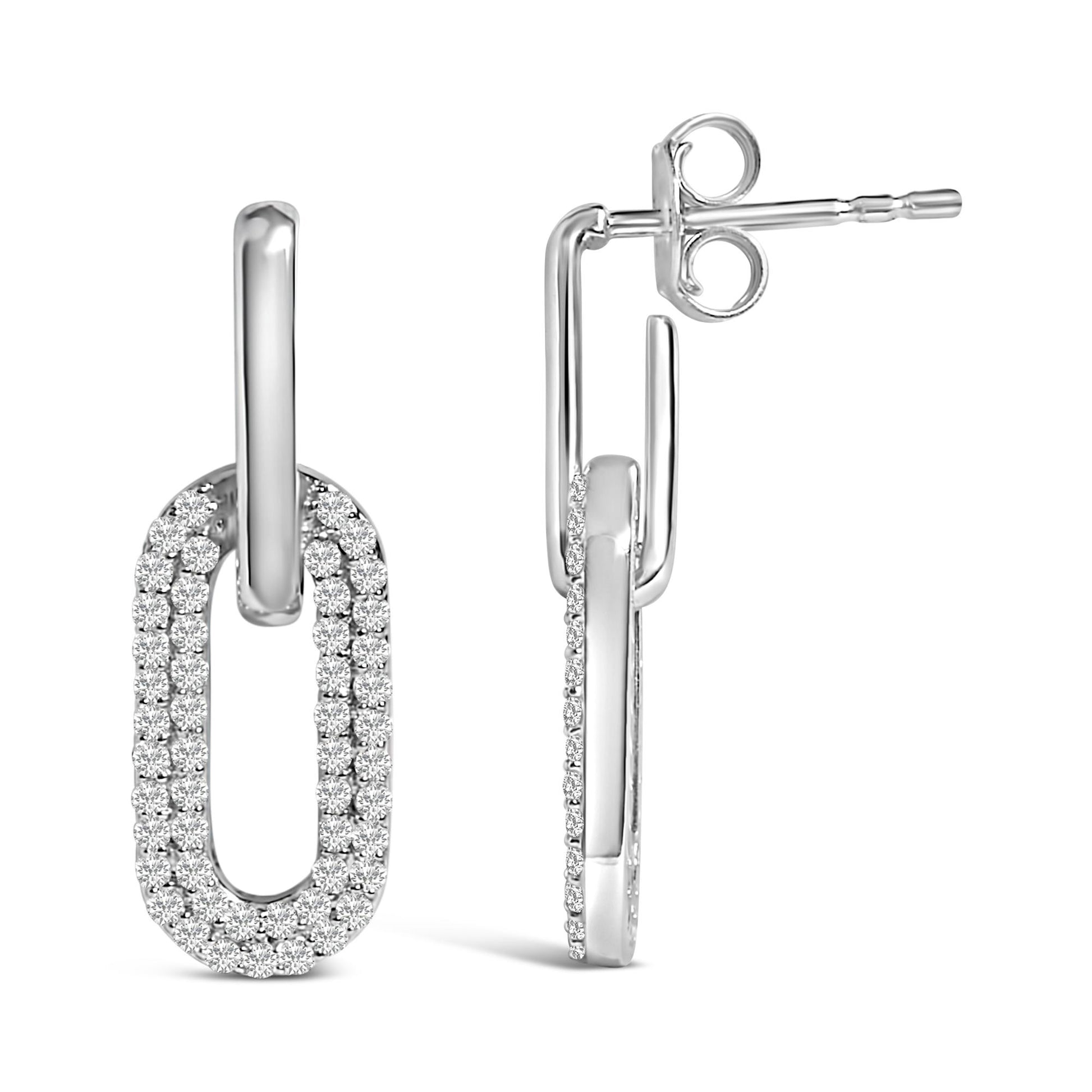 Pair of white metal earrings shown from front and side angles, each featuring an elongated oval shape encrusted with two rows of round white gemstones in a shared prong setting.