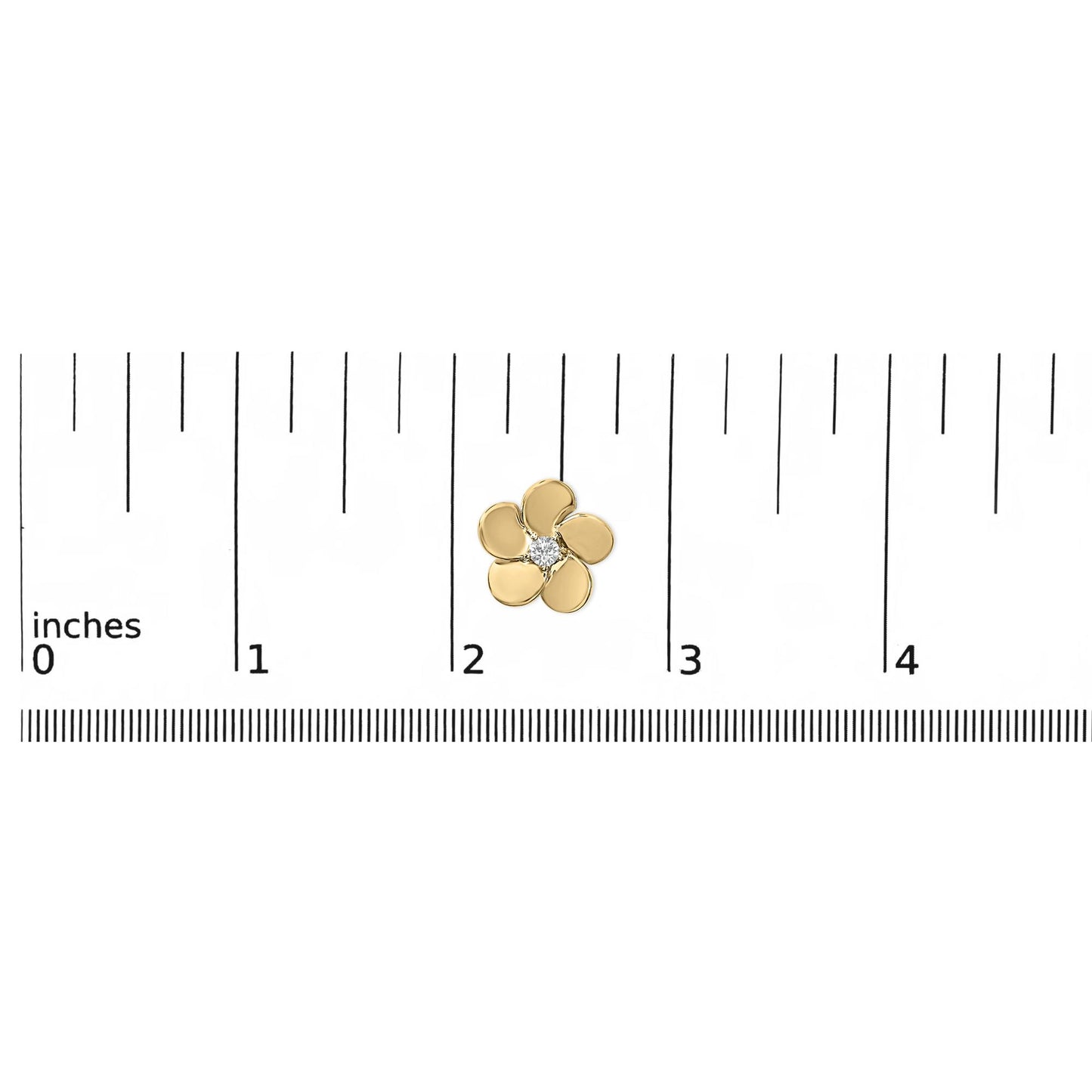 Close-up top view of a small yellow metal flower-shaped earring with a single white round gemstone in the center, shown placed on a ruler scale.