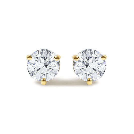 Close-up front view of yellow metal round stud earrings featuring two white gemstones in 3-prong settings.