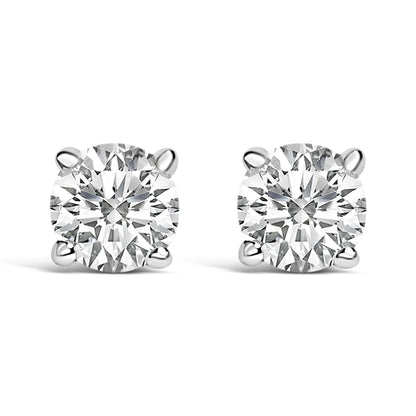 Close-up front view of a pair of white metal stud earrings, each featuring a round white gemstone in a four-prong setting.
