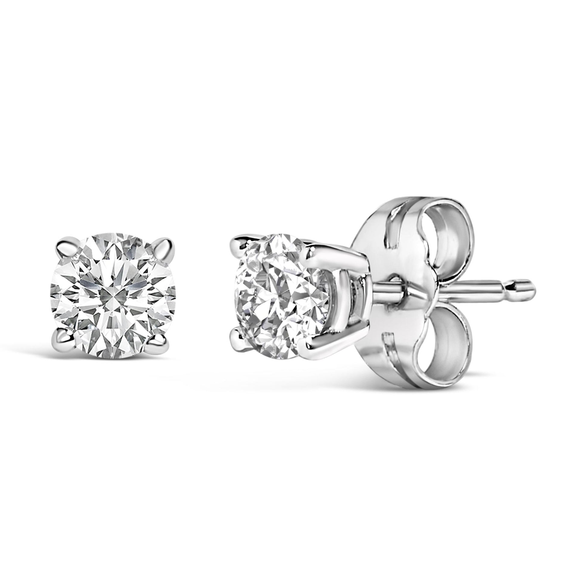 Close-up front and side view of a pair of white metal stud earrings featuring round white gemstones in 4-prong settings.