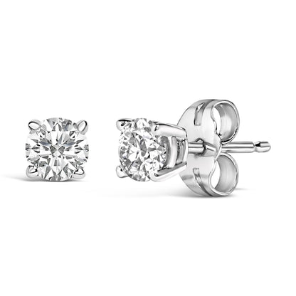 Close-up front and side view of a pair of white metal stud earrings featuring round white gemstones in 4-prong settings.