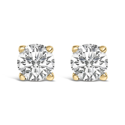 Front view of a pair of yellow metal stud earrings each set with a round white gemstone in a four-prong setting, shown on a white background.