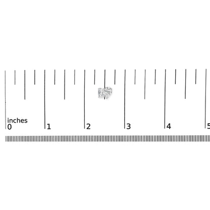 White metal earrings with one emerald-shaped white gemstone in four-prong setting and one pear-shaped white gemstone in three-prong setting, shown on a ruler for scale from a top-front angle.