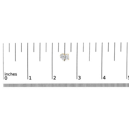 Close-up front view of a pair of yellow metal earrings shown on a scale, featuring one white emerald-shaped gemstone in a four-prong setting and one white pear-shaped gemstone in a three-prong setting.