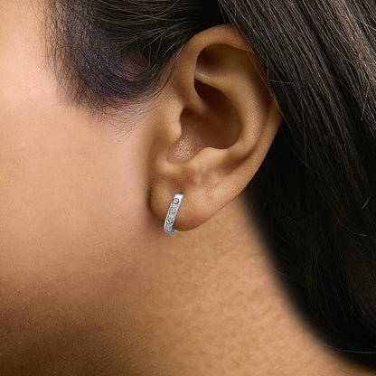Close-up profile shot of a model wearing a white metal hoop earring featuring six round white gemstones in bezel settings along the front.