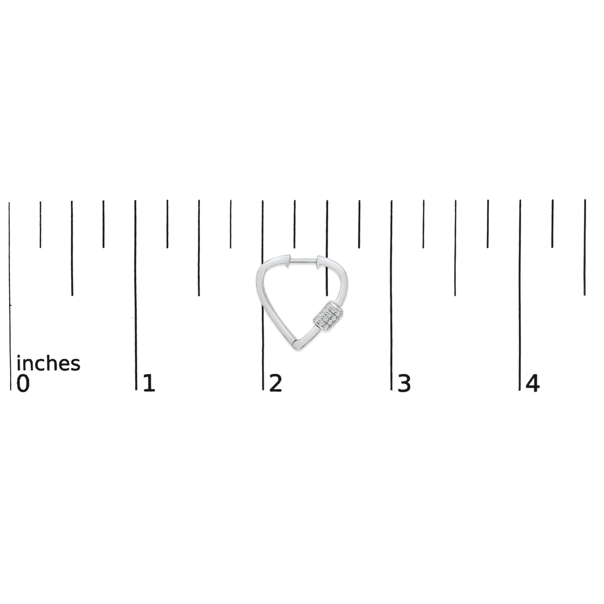 White metal earring with a triangular shape and a clustered section of small round white gemstones, shown on a scale from above.