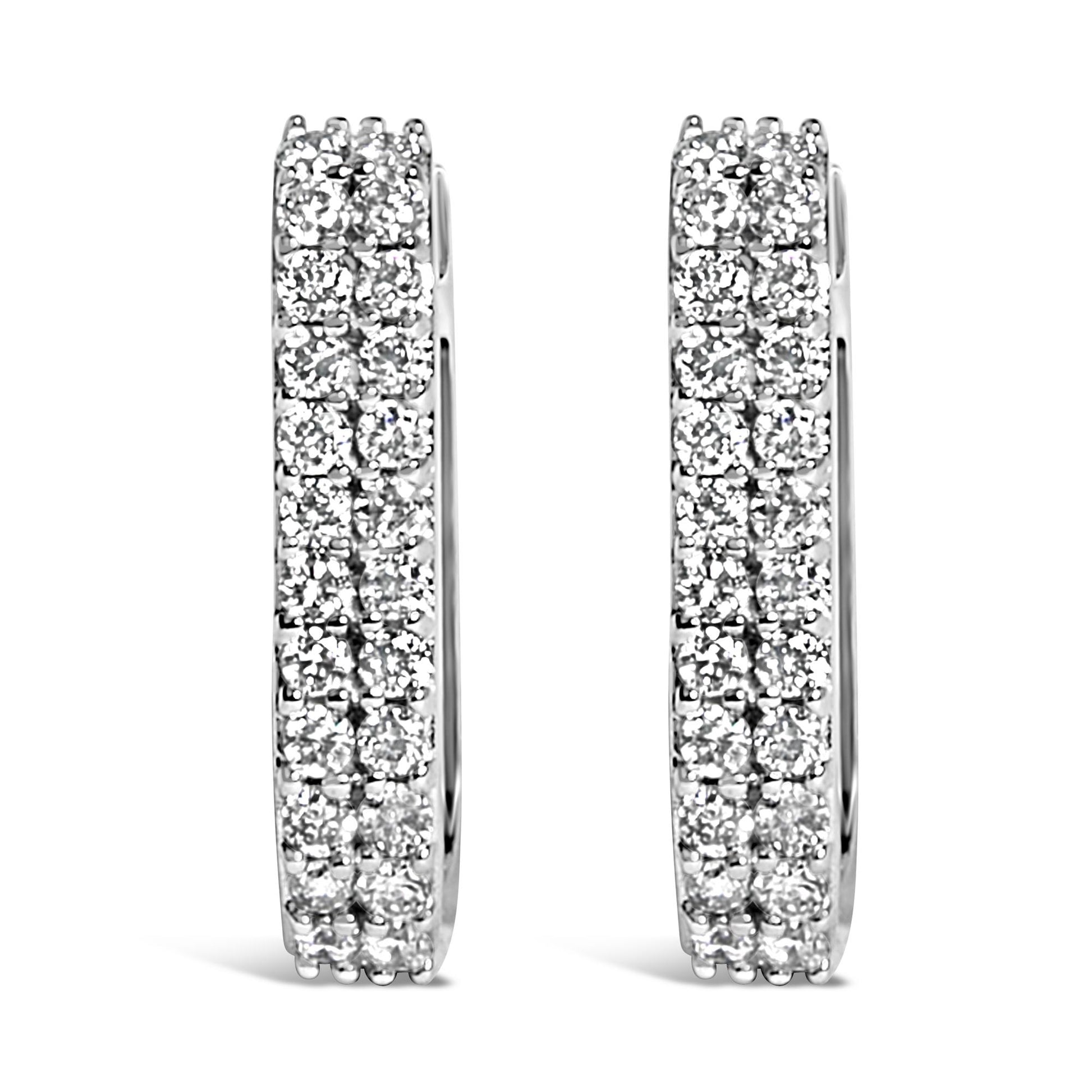 Close-up front view of a pair of white metal hoop earrings with multiple rows of round white gemstones in a shared prong setting, shown against a white background.
