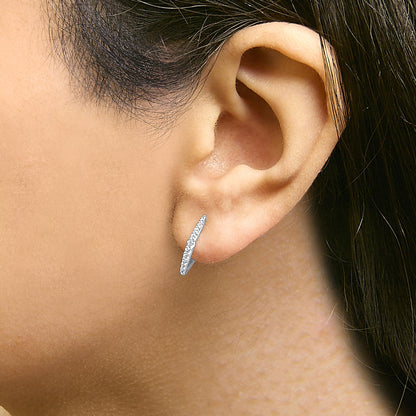 Close-up side view of a white metal earring worn on a model’s ear, featuring a row of round white gemstones in a shared prong setting.
