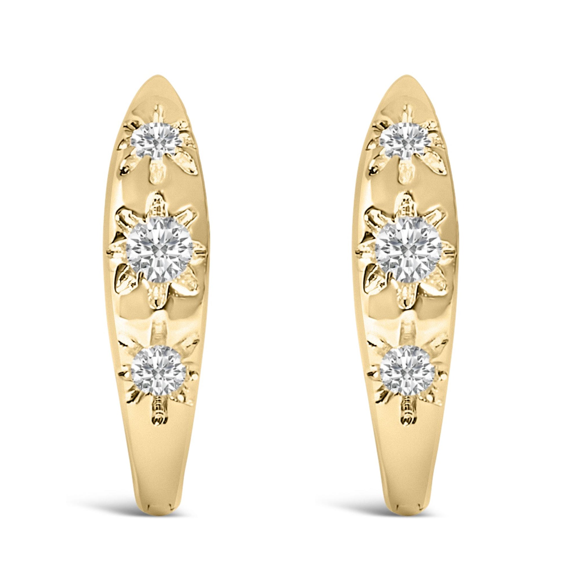 Pair of yellow metal earrings shown from front angle, each with three round white gemstones in prong settings arranged vertically with floral designs.