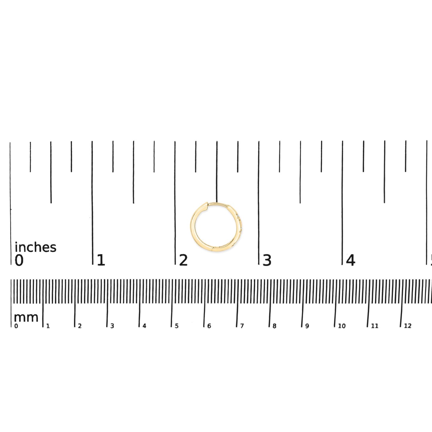 Yellow metal hoop earring with six round white gemstones in prong settings, shown on a scale from above.