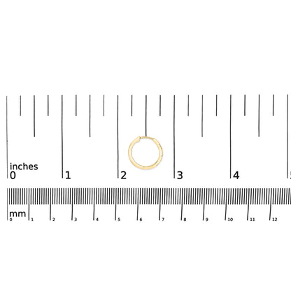 Yellow metal hoop earring with six round white gemstones in prong settings, shown on a scale from above.
