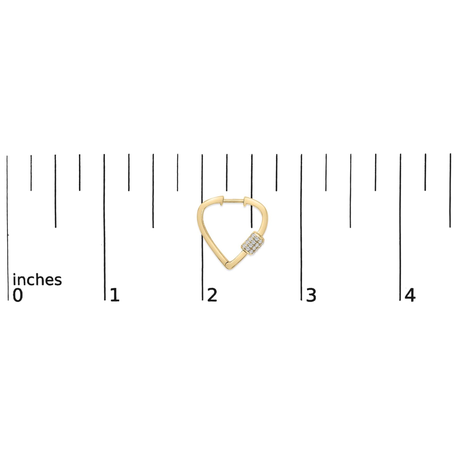 Yellow metal earring with a triangular shape and a cluster of small white gemstones on one side, shown on a scale from a top front angle.