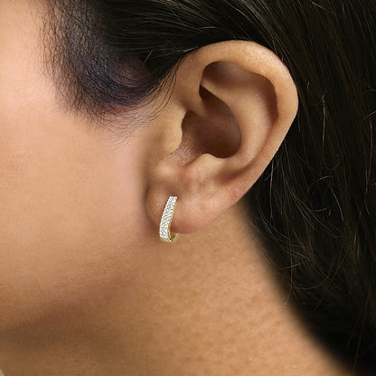 Close-up side angle of a model wearing a yellow-colored small hoop earring with two rows of round white gemstones in shared prong setting.