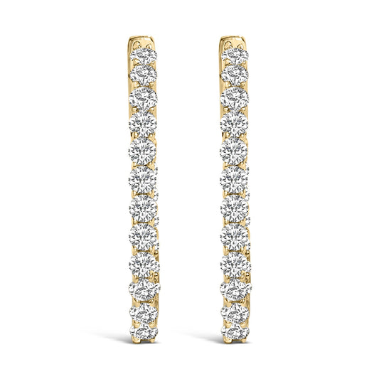 Front view of a pair of yellow metal hoop earrings, each adorned with a vertical line of round white gemstones in a shared prong setting.