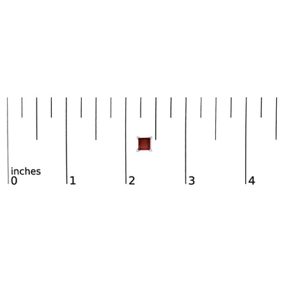 Close-up top view of a red princess-shaped gemstone earring with four-prong white metal setting shown on a ruler scale.