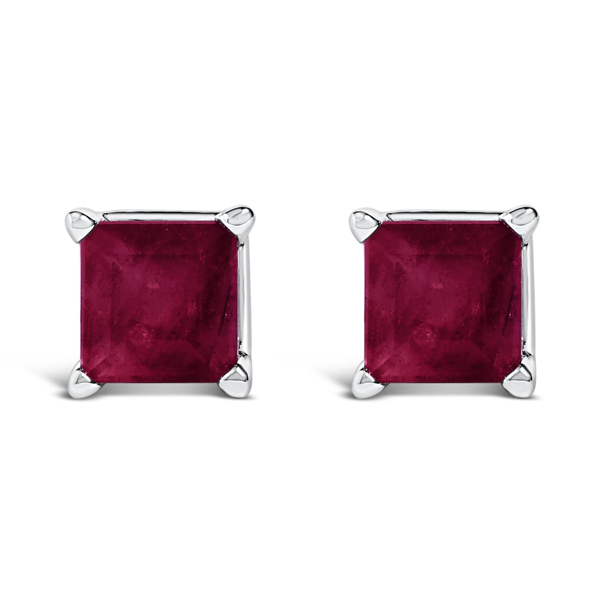 Close-up front view of a pair of white metal square stud earrings with princess-cut red gemstones in four-prong settings.