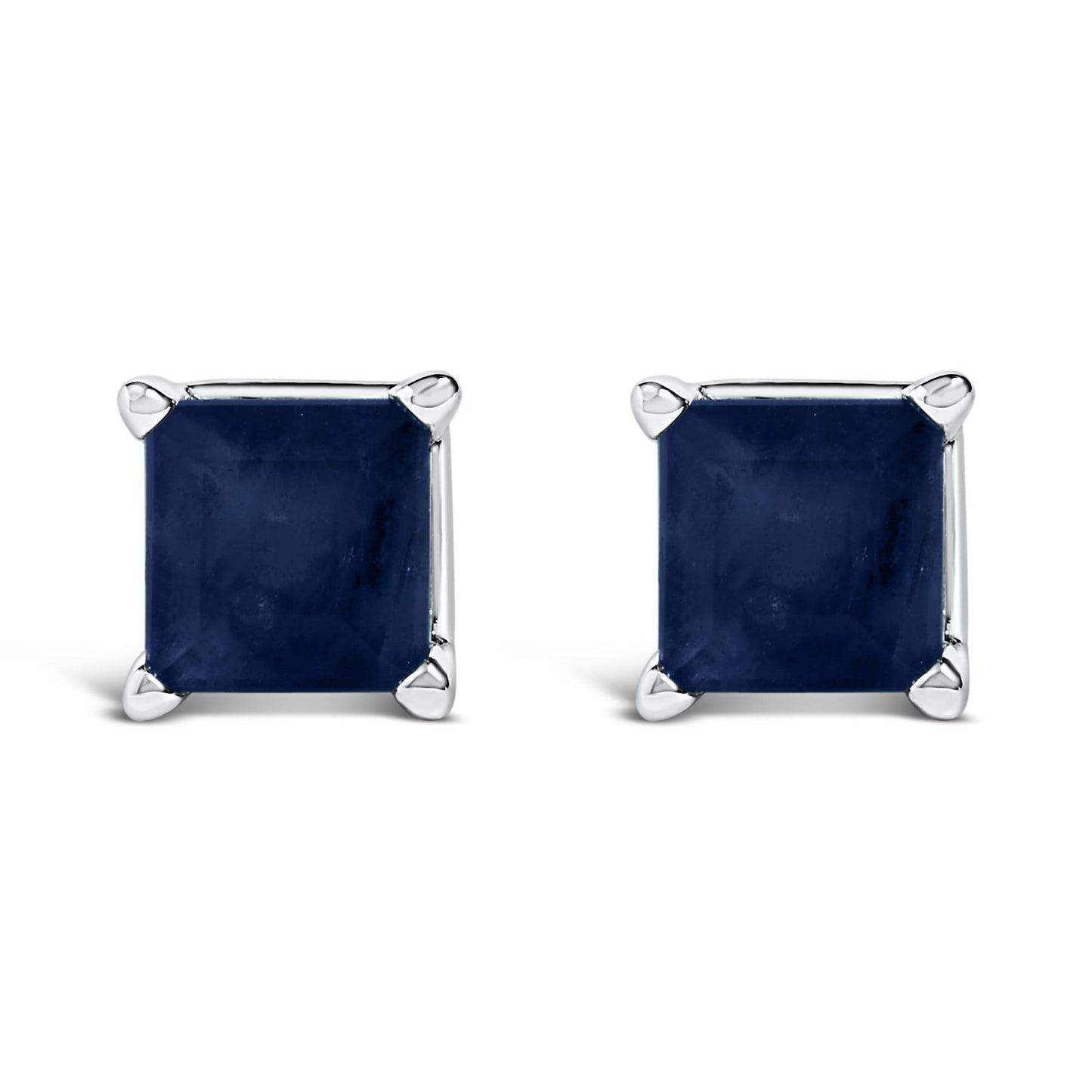 Front angled view of white metal stud earrings featuring square blue gemstones set in four-prong settings.