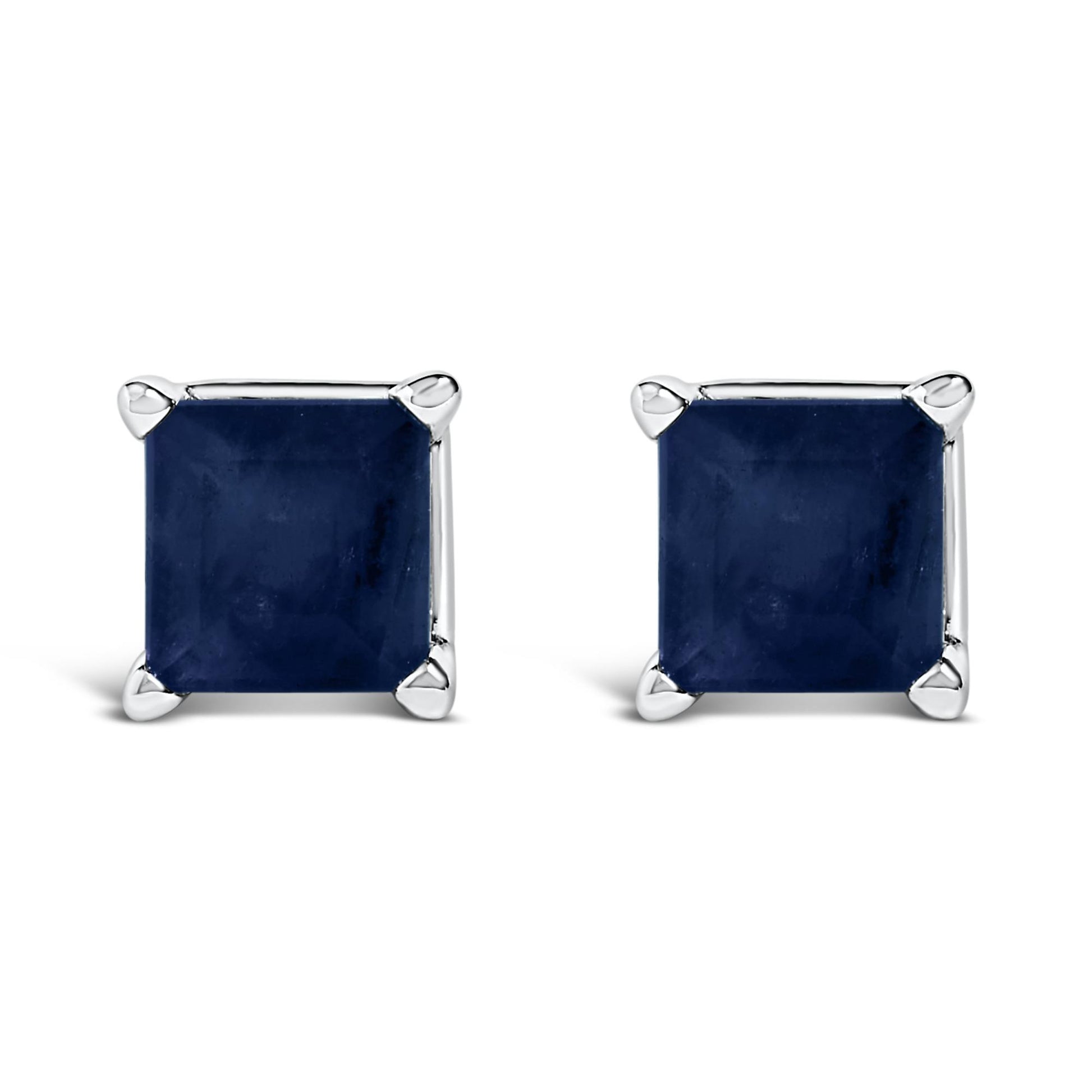 Front angled view of white metal stud earrings featuring square blue gemstones set in four-prong settings.