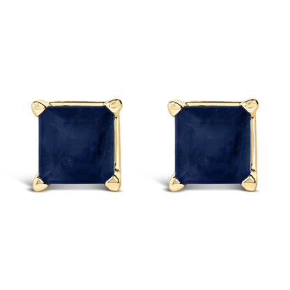 Front view of a pair of yellow metal stud earrings, each set with a blue princess-shaped gemstone in a four-prong setting.