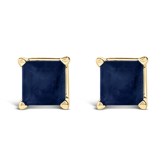 Front view of a pair of yellow metal stud earrings, each set with a blue princess-shaped gemstone in a four-prong setting.