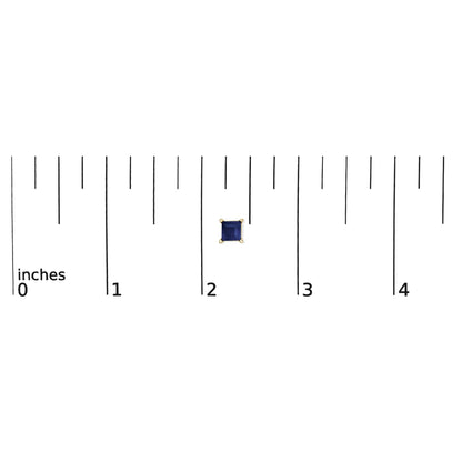 Close-up front view of a single yellow metal earring with a square blue gemstone in a four-prong setting, shown on a scale.