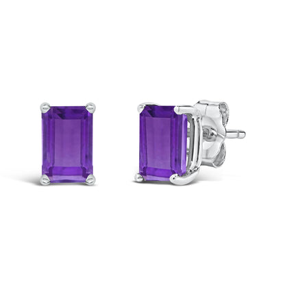 Pair of white metal stud earrings with emerald-shaped purple gemstones in four-prong settings, shown from a front and side angle on a white background.