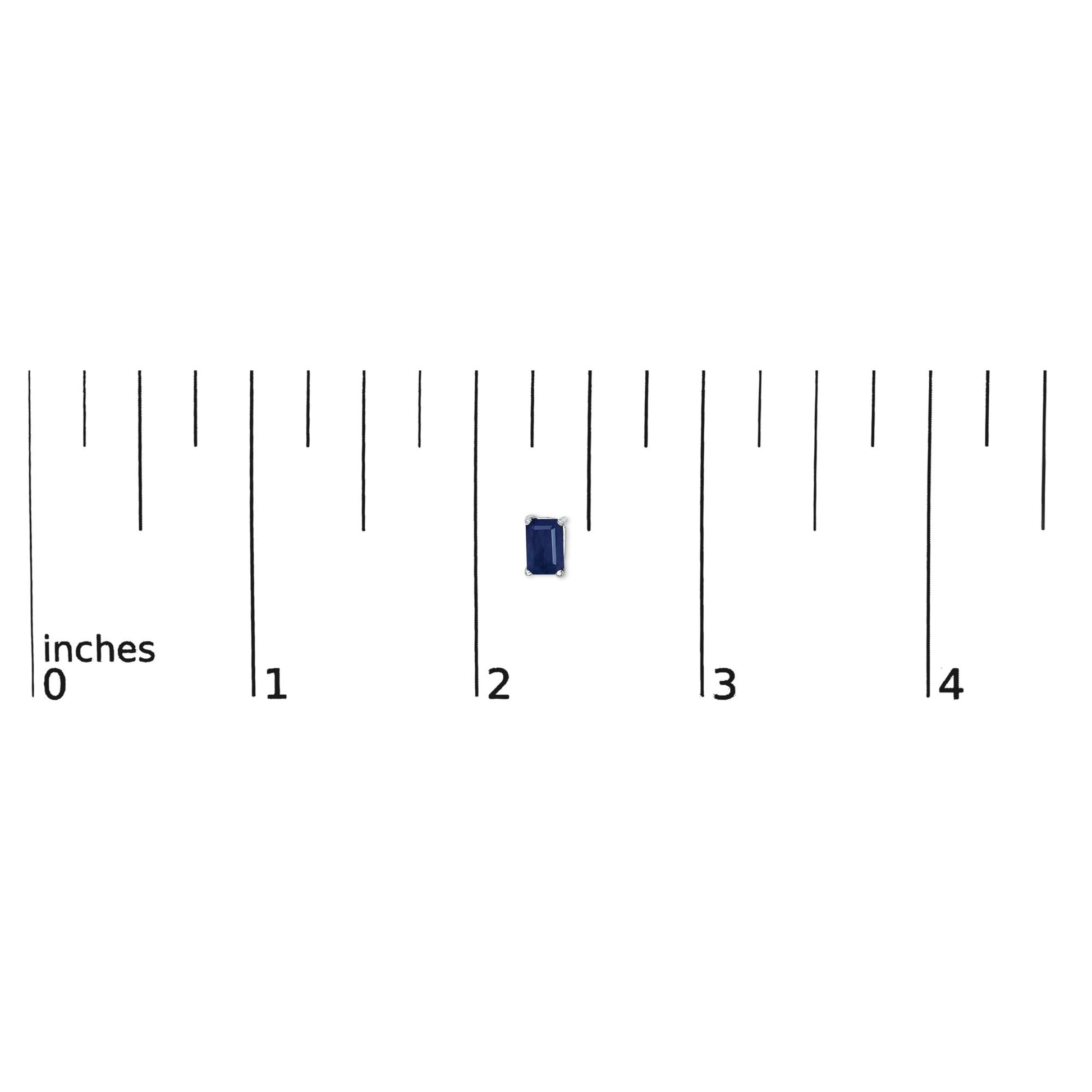 Single white metal earring with a blue emerald-shaped gemstone in a four-prong setting, shown on a ruler for scale from a top-down angle.