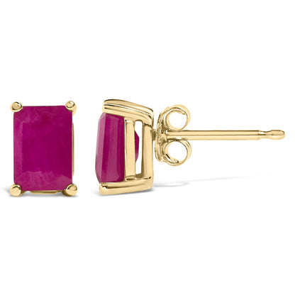 Close-up side and front angle of a pair of yellow metal stud earrings each featuring a rectangular red gemstone set in four prongs.