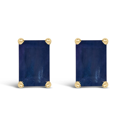 Front view of a pair of yellow metal stud earrings featuring rectangular blue gemstones with four-prong settings.