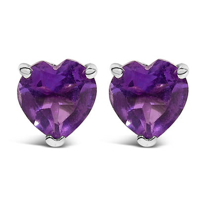 Pair of white metal stud earrings with purple heart-shaped gemstones in a 3-prong setting, shown from a front angle.