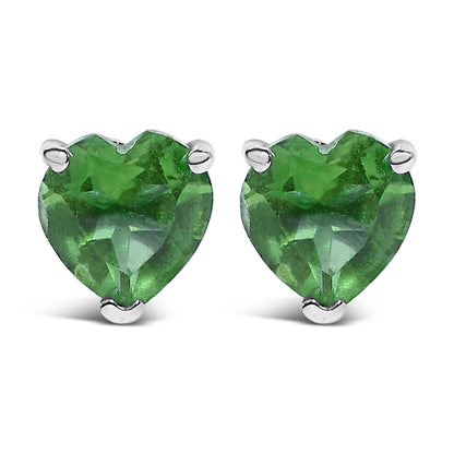 Front view of white metal stud earrings featuring heart-shaped green gemstones in three-prong settings.
