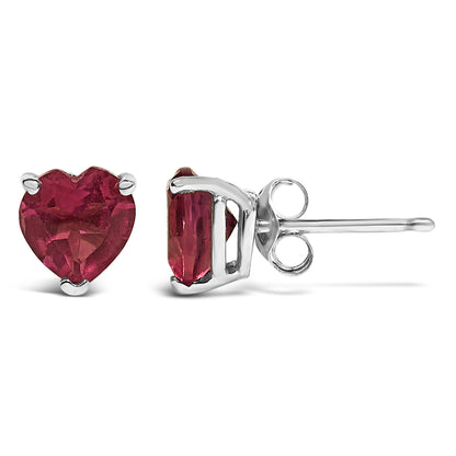 Pair of white metal stud earrings with heart-shaped red gemstones in 3-prong settings, shown from front and side angles on a white background.