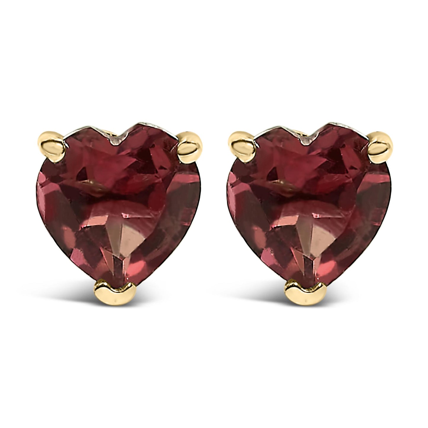 Close-up front view of a pair of yellow metal stud earrings, each featuring a heart-shaped red gemstone set with three prongs.