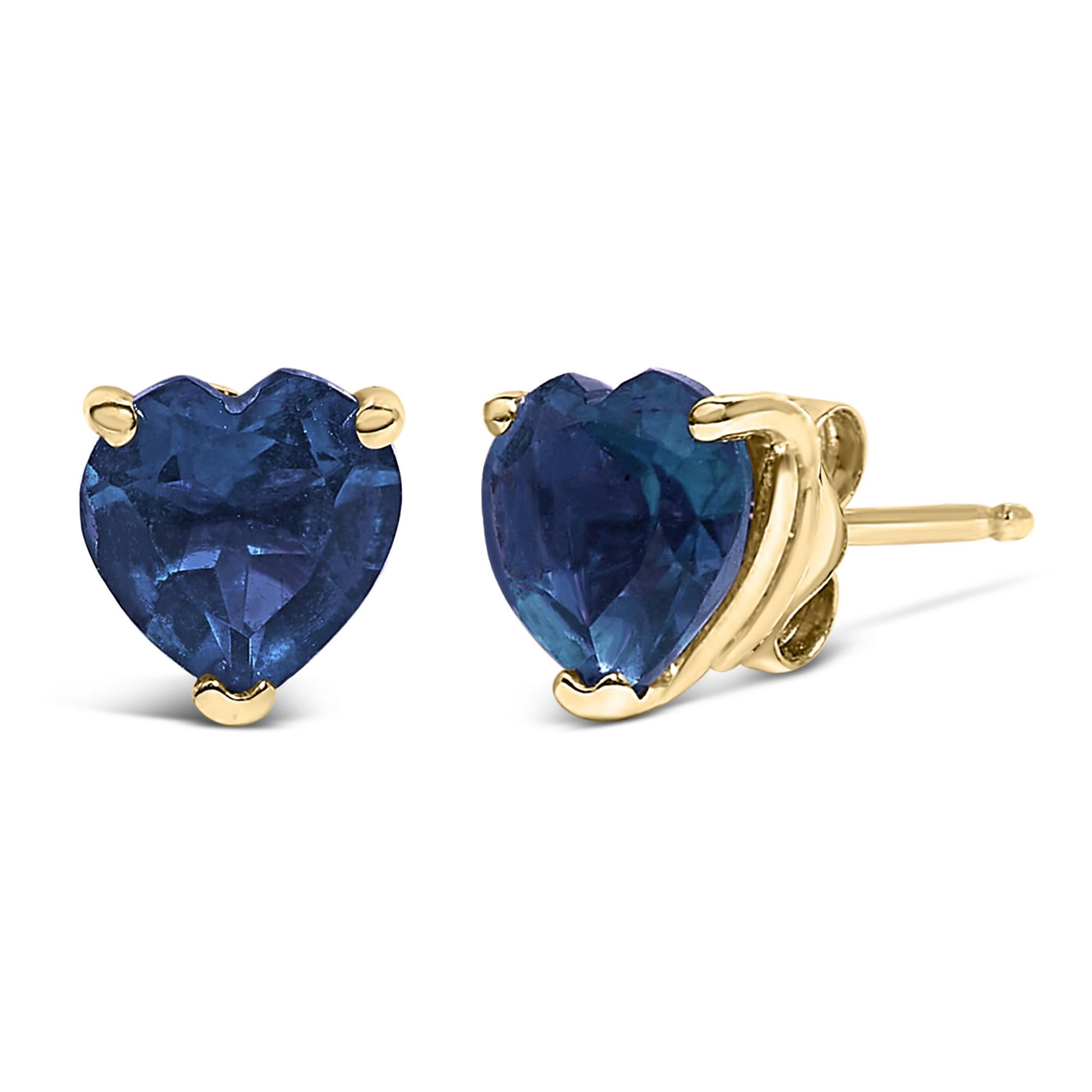 Close-up front and side view of yellow metal stud earrings with heart-shaped blue gemstones in a three-prong setting.