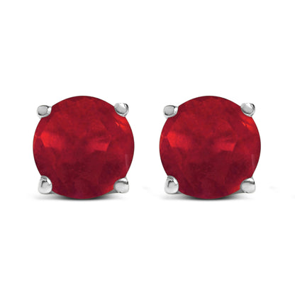 Front view of white metal stud earrings with round red gemstones in a four-prong setting.