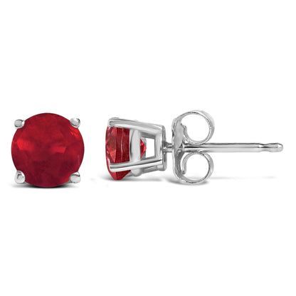 Pair of white metal stud earrings with round red gemstones in four-prong settings, shown in front and side views on a white background.
