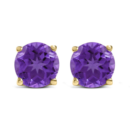 Close-up front view of yellow metal stud earrings each featuring a round purple gemstone in a four-prong setting.