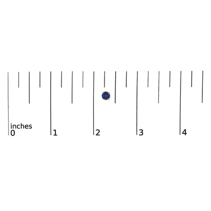 Close-up top view of round blue gemstone stud earring set in yellow metal prongs, shown on a ruler scale.