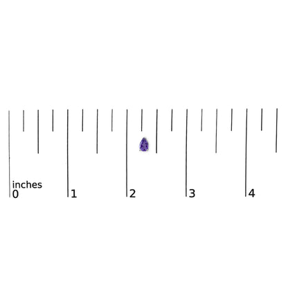 Pear-shaped purple gemstone earring with three-prong white setting shown on a ruler scale, top-down angle.
