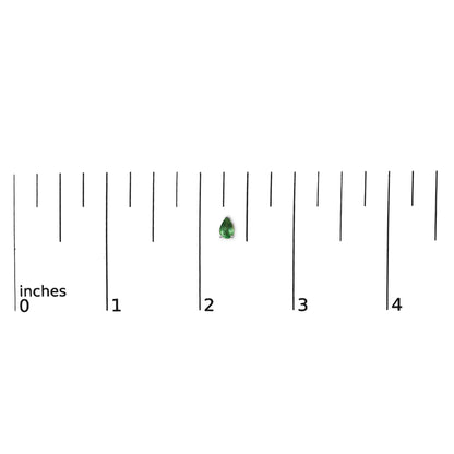 Close-up front view of a white metal pear-shaped green gemstone earring shown on a ruler scale.