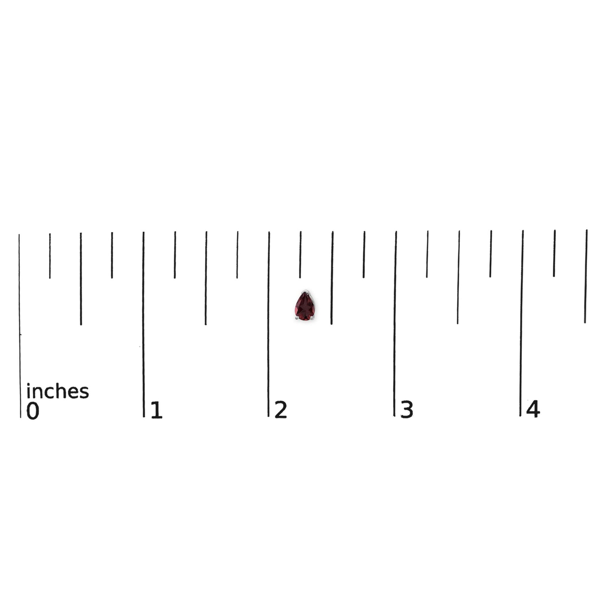 White metal pear-shaped red gemstone earring shown on a ruler scale, front-facing angle.