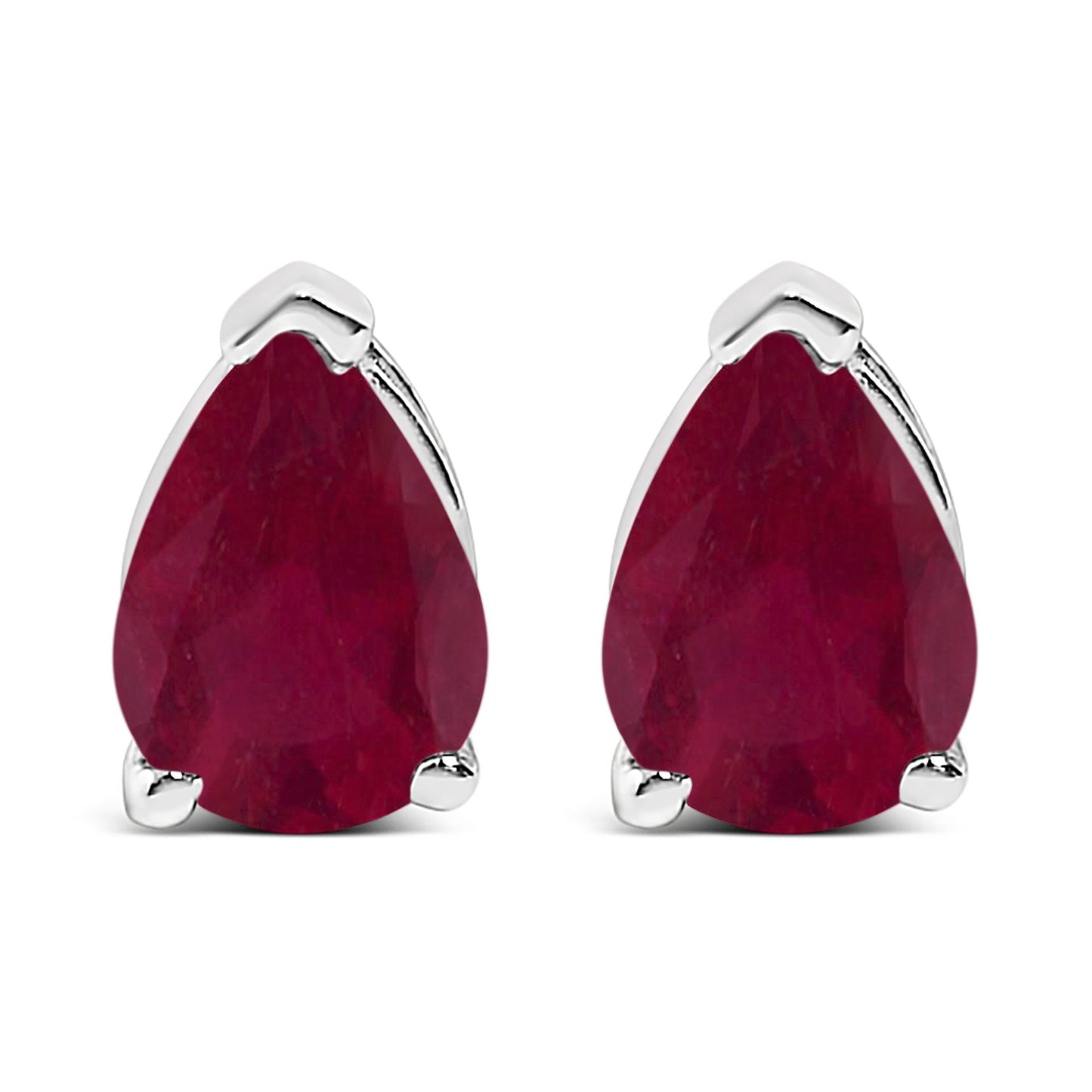 Close-up front view of a pair of white metal earrings, each featuring a pear-shaped red gemstone with a three-prong setting.