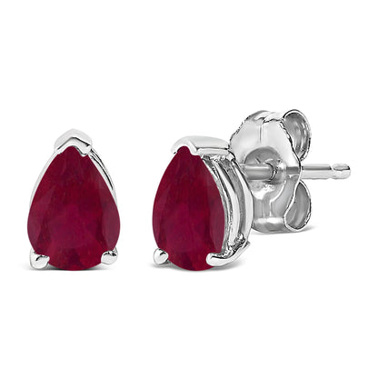 Pair of white metal stud earrings with pear-shaped red gemstones in a three-prong setting, shown from a close-up side and front angle.